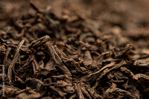 Large-leaved black tea in bulk on the table. Close-up of the surface texture