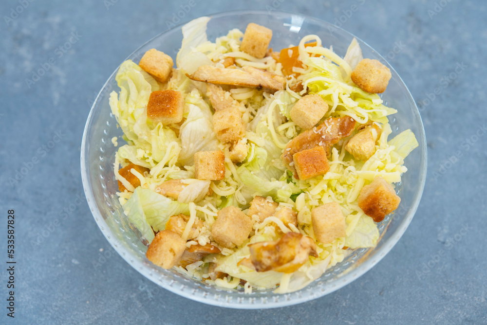 Caesar salad with toast, lettuce and grilled chicken breast and cheese