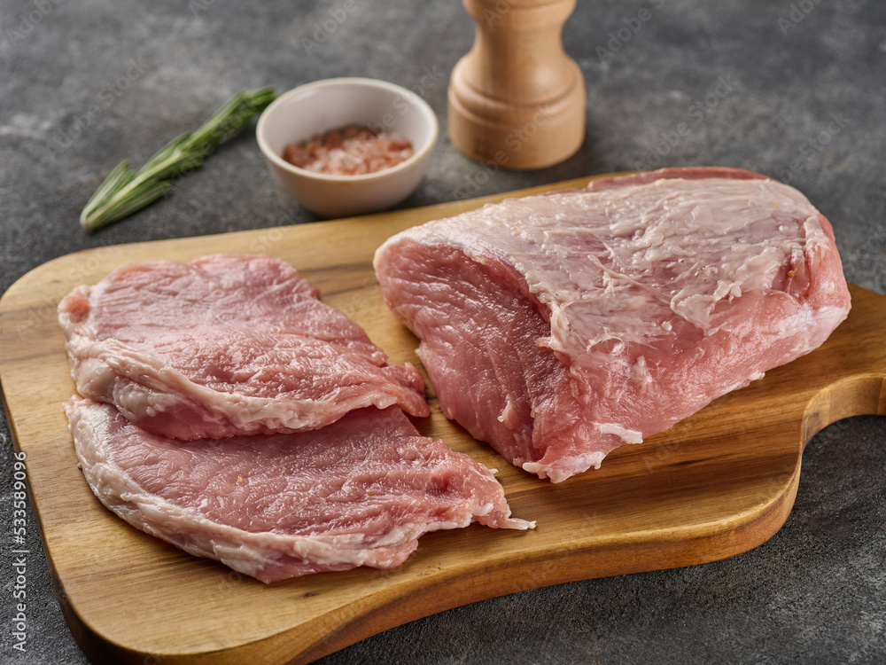 Raw Pork Loin. Pork meat and slices meat on grey background Raw Pork Loin. Pork meat and slices meat on grey background