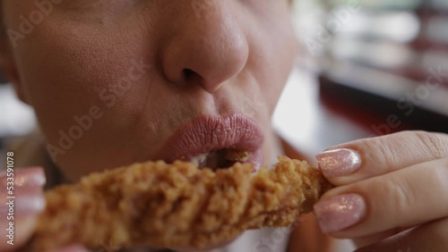 Woman eating fried chicken in fast food.