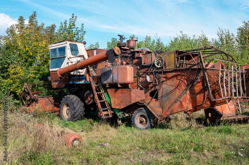 Old rusty agricultural machinery. Abandoned harvester, tractor Old rusty agricultural machinery. Abandoned harvester, tractor