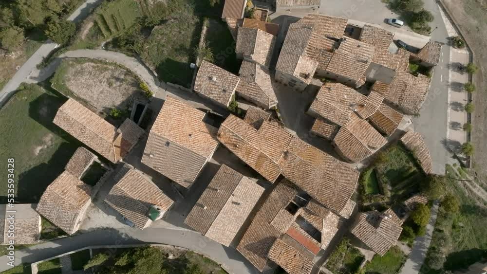 Aerial orbiting top down descending over roofs of small country village Aerial orbiting top down descending over roofs of small country village