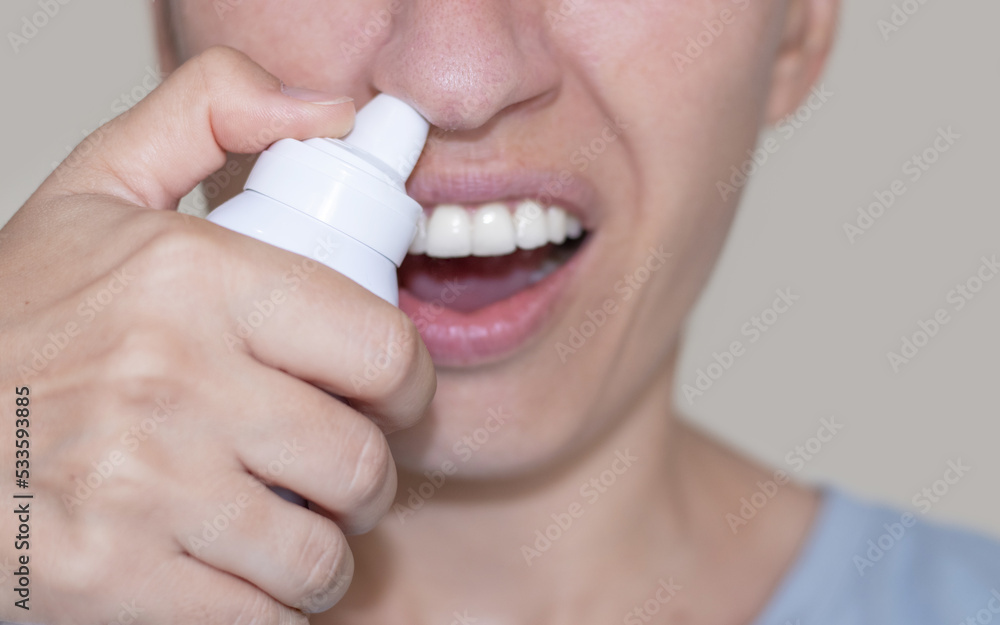 sore throat and runny nose treatment. woman using lozenge candy spray for red painful throat or