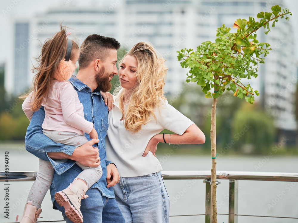 Man and woman with child outdoors. Father holding adorable child while ...