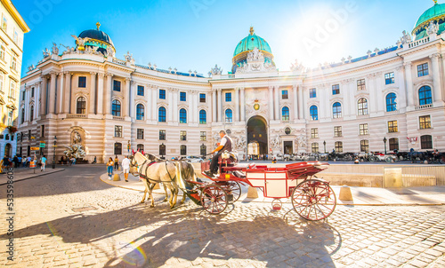 Stampa su tela Hofburg Palace and horse carriage on sunny Vienna street, Austria
