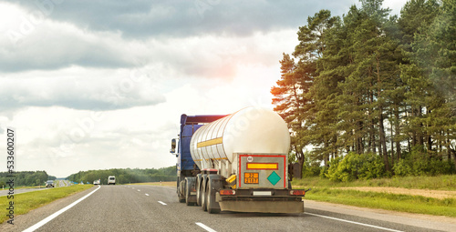 A truck with a semi-trailer tank transports a dangerous cargo of liquefied gas. The concept of transportation of flammable goods. Copy space for text, industry