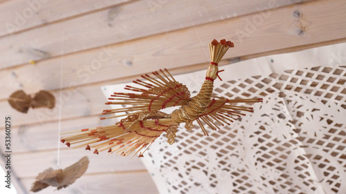 a bird made of straw suspended on a thread. Handmade, traditional. photo