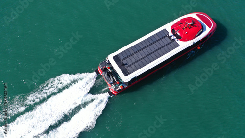 Aerial drone photo of latest technology high speed passenger ferry or "flying dolphin" with photovoltaic panels on top cruising in high speed  near port of Piraeus, Attica, Greece