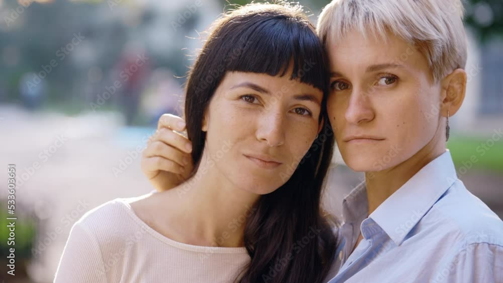 Portrait of a cute lesbian couple looking at the camera. Two happy female friends posing in the city centre , feeling in love together. Woman relationships, lgbt concept Portrait of a cute lesbian couple looking at the camera. Two happy female friends posing in the city centre , feeling in love together. Woman relationships, lgbt concept