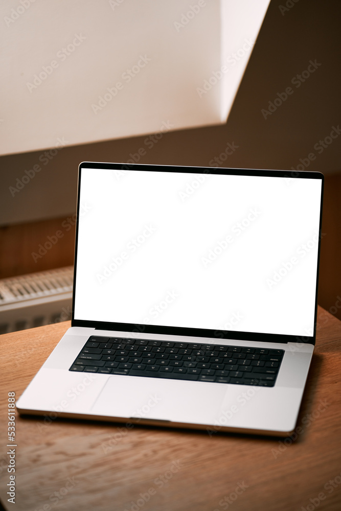 Concept of working remotely and using laptop indoors. Laptop mockup on a wooden table, blank computer screen. Scandinavian interior and rooftop window. Concept of working remotely and using laptop indoors. Laptop mockup on a wooden table, blank computer screen. Scandinavian interior and rooftop window.