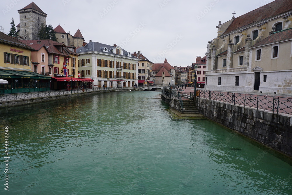 view of the old colorful buildings of the town of annecy france by the river from the bridge