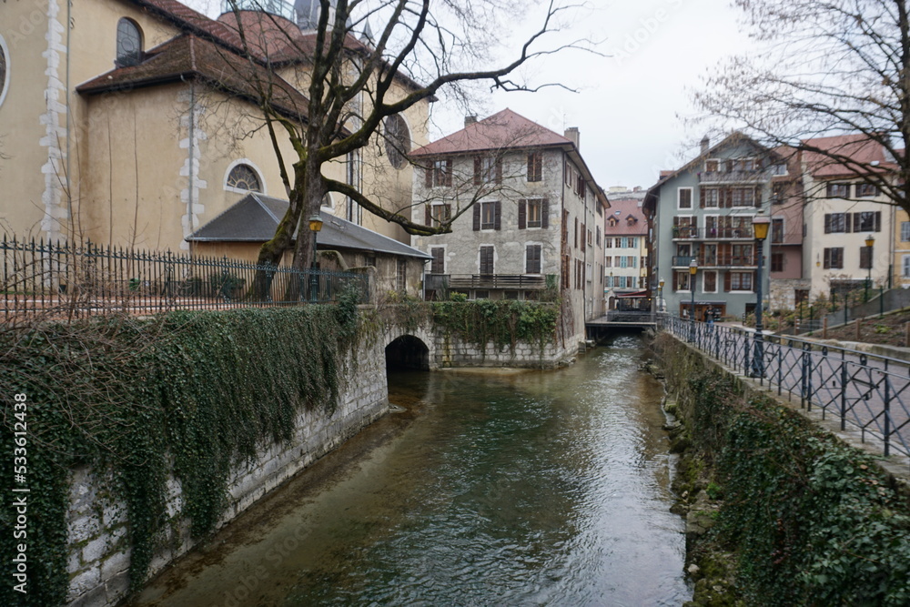view of the old colorful buildings of the town of annecy france by the river from the bridge