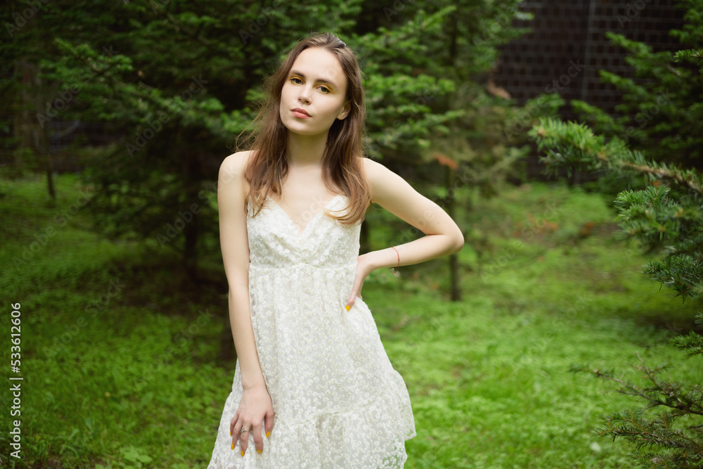 City portrait of beautiful young woman in white dress.