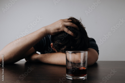 Photos Alcoholism, depressed man sleep on table while drinking alcoholic beverage with