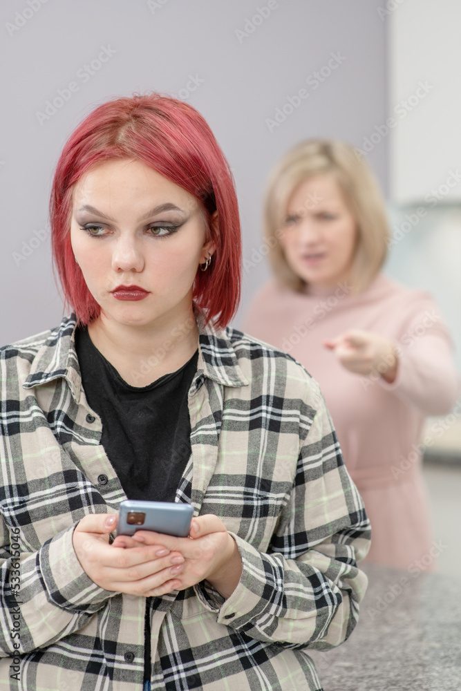 Angry mother scolds her teenage daughter, girl uses smartphone and ignores her mom. Family relationships Angry mother scolds her teenage daughter, girl uses smartphone and ignores her mom. Family relationships
