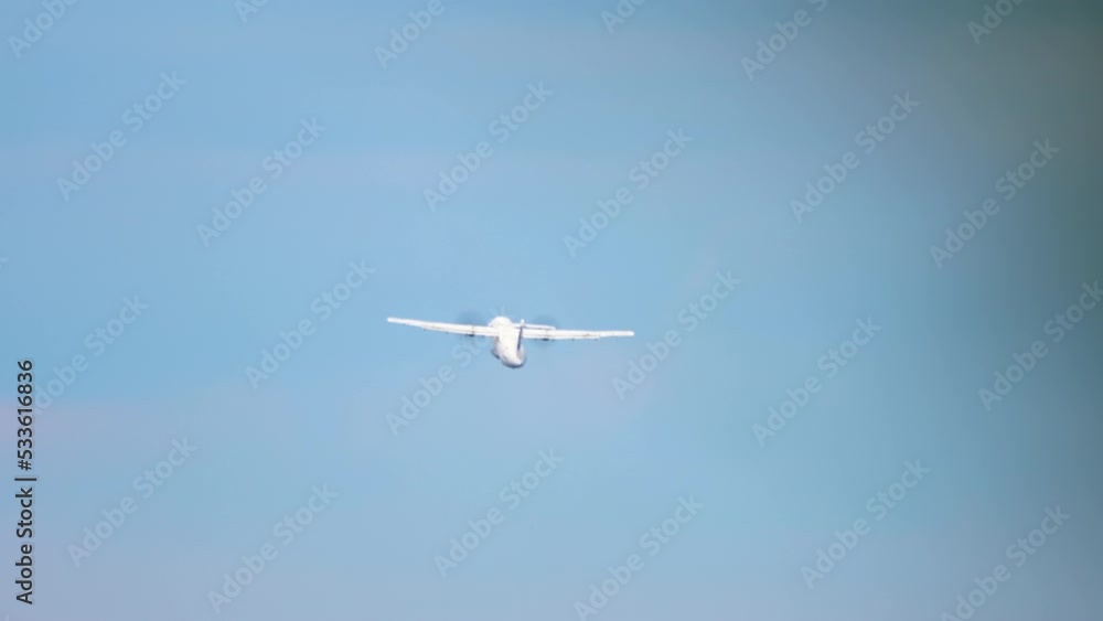 Turboprop airplane taking off and climbing. Rear view, passenger plane flies away. Tourism and travel concept Turboprop airplane taking off and climbing. Rear view, passenger plane flies away. Tourism and travel concept