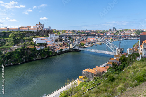 Metallic bridge of Don Luis I in Porto, with a part scaffolded for works, on a sunny day.