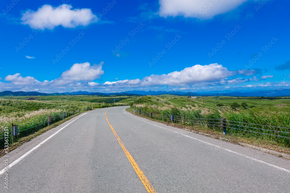 青空広がる阿蘇ミルクロードのドライブ風景（熊本県阿蘇市）