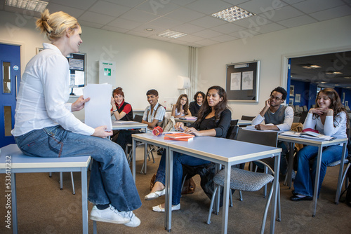 Teenage Students: Classroom. A teacher in a relaxed and informal mood with her attentive and inspired class. From a series of related images.