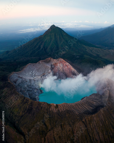 Stunning sunrise views from the top of Ijen volcano with a blue sulfur lake and blue fire in Java Indonesia photo