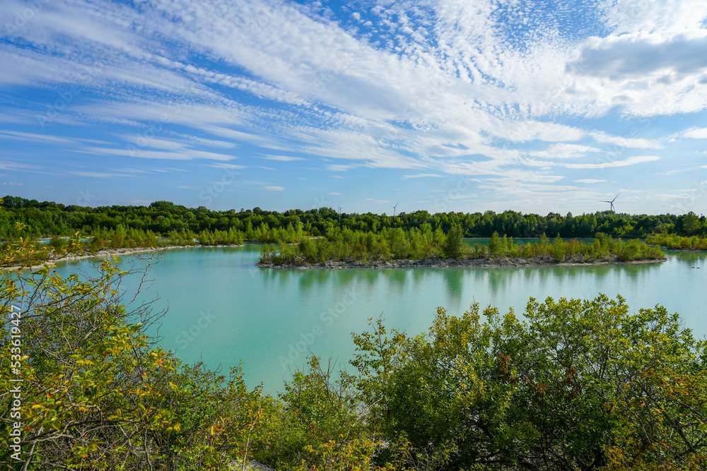 View of the Dyckerhoff lake in Beckum. Quarry west. Blue Lagoon. Landscape with a turquoise blue lake and the surrounding nature.
View of the Dyckerhoff lake in Beckum. Quarry west. Blue Lagoon. Landscape with a turquoise blue lake and the surrounding nature.