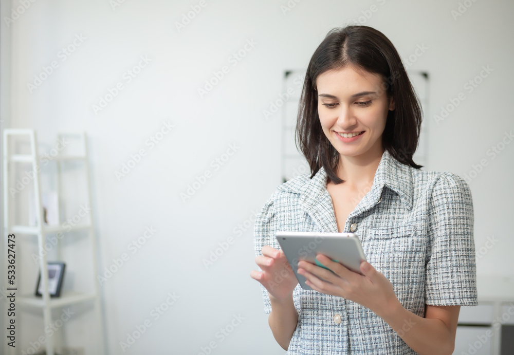 Beautiful woman smiling and looking at her working on tablet. businesswoman using digital tablet online job or browsing information. Beautiful woman smiling and looking at her working on tablet. businesswoman using digital tablet online job or browsing information.