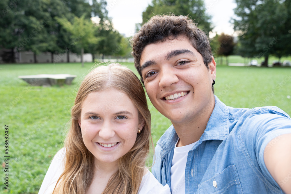Real camera view of teenager couple taking selfie outdoors in a park Real camera view of teenager couple taking selfie outdoors in a park