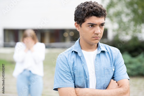 Angry and serious hispanic boy leaving girlfriend after breakup.
