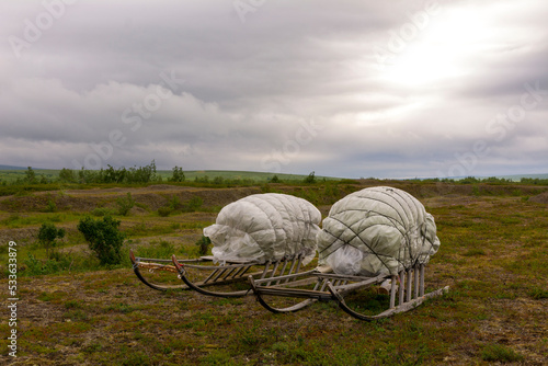 Wooden sledges with cargo in the tundra in the north in summer.