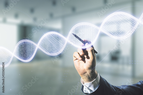 Male hand with pen working with DNA hologram on blurred interior background, biotechnology and genetic concept. Multiexposure © Pixels Hunter