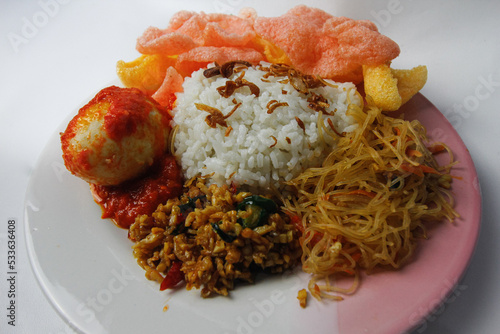 Nasi Uduk is a typical Jakarta Betawi dish, containing rice in coconut milk, vermicelli, eggs, kerupuk, tempe orek, and sambal photo