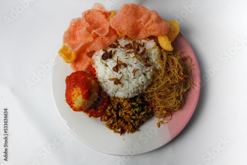 Nasi Uduk is a typical Jakarta Betawi dish, containing rice in coconut milk, vermicelli, eggs, kerupuk, tempe orek, and sambal photo