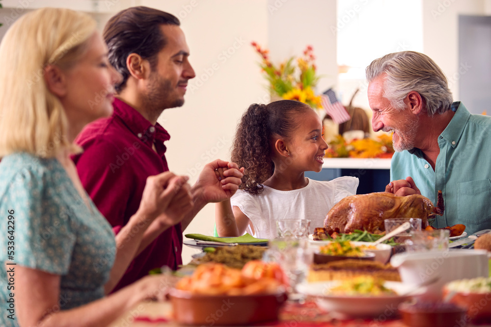 Multi-Generation Family Celebrating Thanksgiving At Home Eating Meal Together