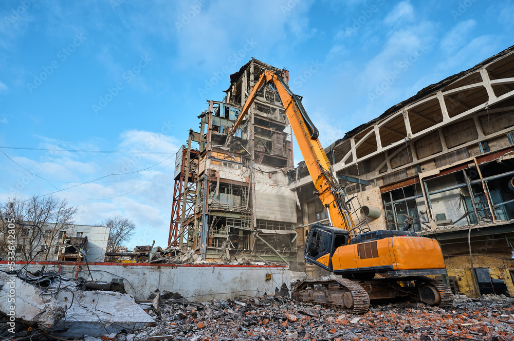 Hydraulic excavators at demolition site of industrial complex Hydraulic excavators at demolition site of industrial complex