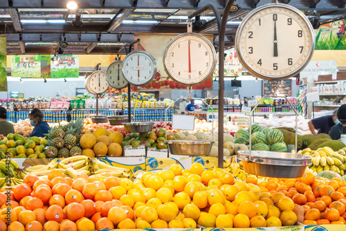 Hanging scales in the greengrocers section of a supermarket for customers to weigh their produce.