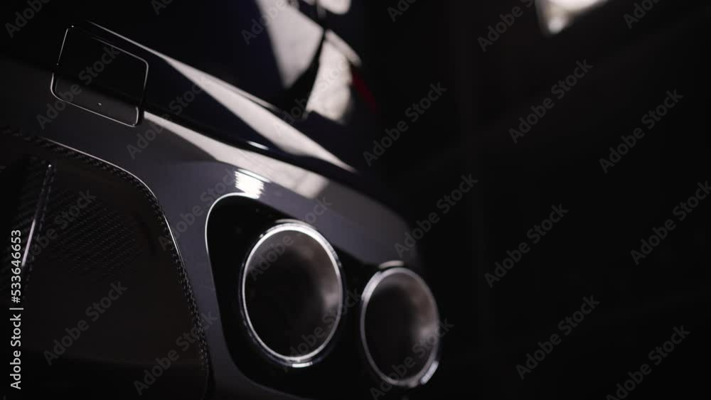 Bottom view of the exhaust system of a new luxury car. Panoramic view. Close-up of a dual exhaust pipe to remove harmful substances from engine exhaust and reduce vehicle noise. Bottom view of the exhaust system of a new luxury car. Panoramic view. Close-up of a dual exhaust pipe to remove harmful substances from engine exhaust and reduce vehicle noise.