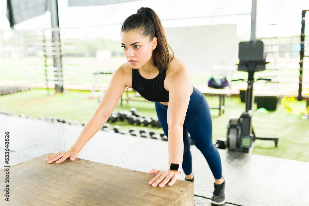 Fit young woman practicing push up exercises with a plyo box Fit young woman practicing push up exercises with a plyo box