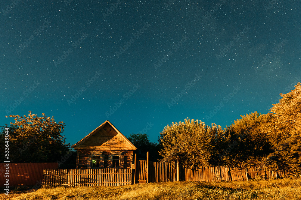 Night sky over house in old village. Night starry sky above house with ...