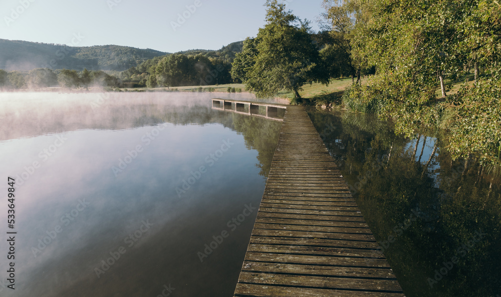 ponton en bois dans la brume automnale sur le lac d'Autun en bourgogne ponton en bois dans la brume automnale sur le lac d'Autun en bourgogne