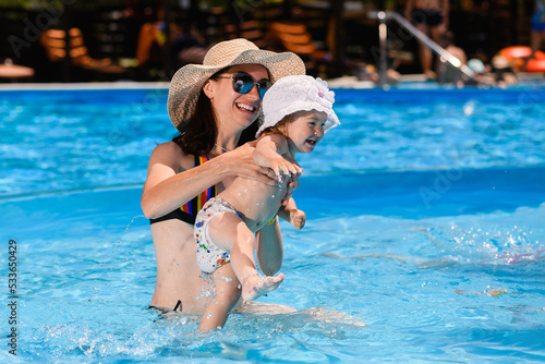 Mother and toddler girl swim in pool © o_lypa