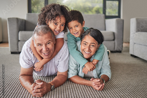 Grandparents, children or bonding in fun play game on house or family home living room floor. Portrait, smile or happy senior man and mature woman babysitting grandchildren or kids together in lounge