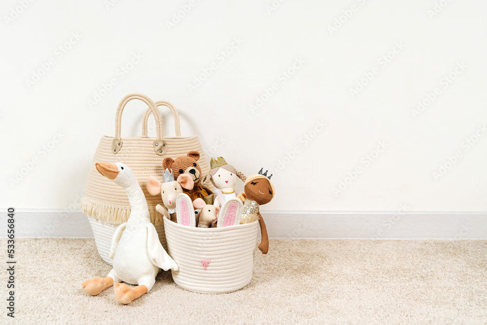 Beige Toy Storage Baskets in the children's room. Cloth stylish Baskets with  toys and rag dolls. Organizing and Storage Ideas in nursery. Clean up toys and reduce the clutter. House cleaning. - obrazy, fototapety, plakaty 