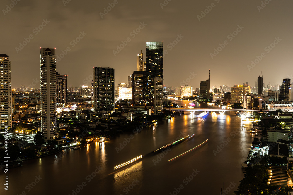 Night cityscape along the Chao Phraya River in Bangkok, Thailand.