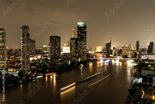 Night cityscape along the Chao Phraya River in Bangkok, Thailand.