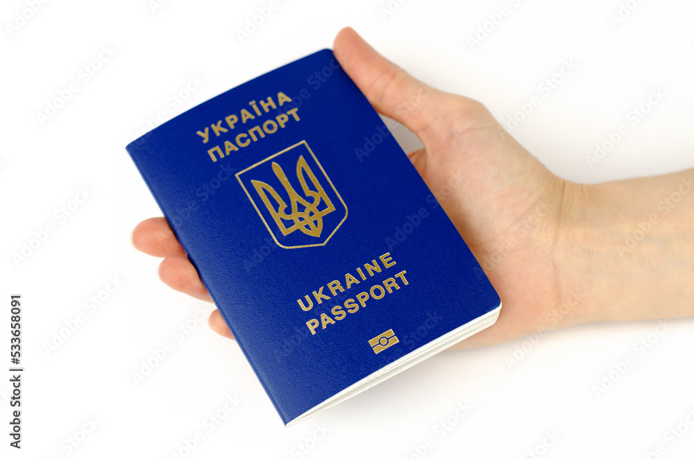 Ukrainian biometric passport in a female hand on a white background. Inscription in Ukrainian Passport of Ukraine Ukrainian biometric passport in a female hand on a white background. Inscription in Ukrainian Passport of Ukraine