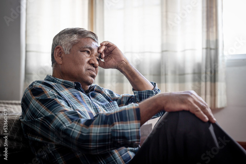 Obraz na plátně lonely elderly Asian man in his 60s sitting at home, sad, depressed, alone