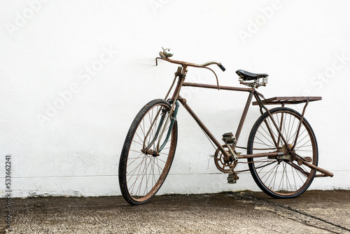 Vintage old bike leaning against white wall background