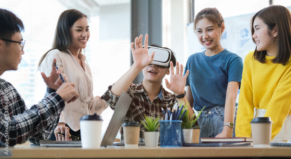 Excited development team working on virtual reality software in modern office. Excited development team working on virtual reality software in modern office.