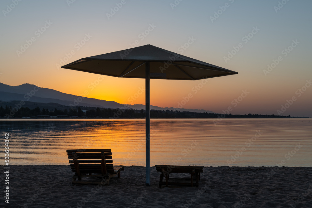 Sunrise on the beach of the picturesque Kyrgyz lake Issyk Kul
