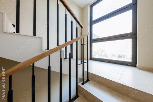 new stylish tile stairs with black metal railings in the house